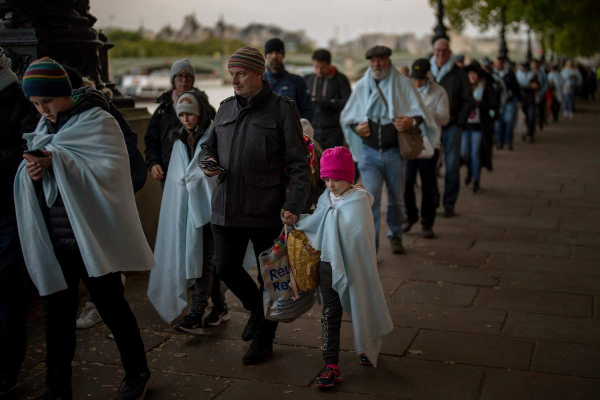 People queue to pay their respects to the late Queen Elizabeth II during the Lying-in State, outside Westminster Hall in London, Sunday, Sept. 18, 2022.