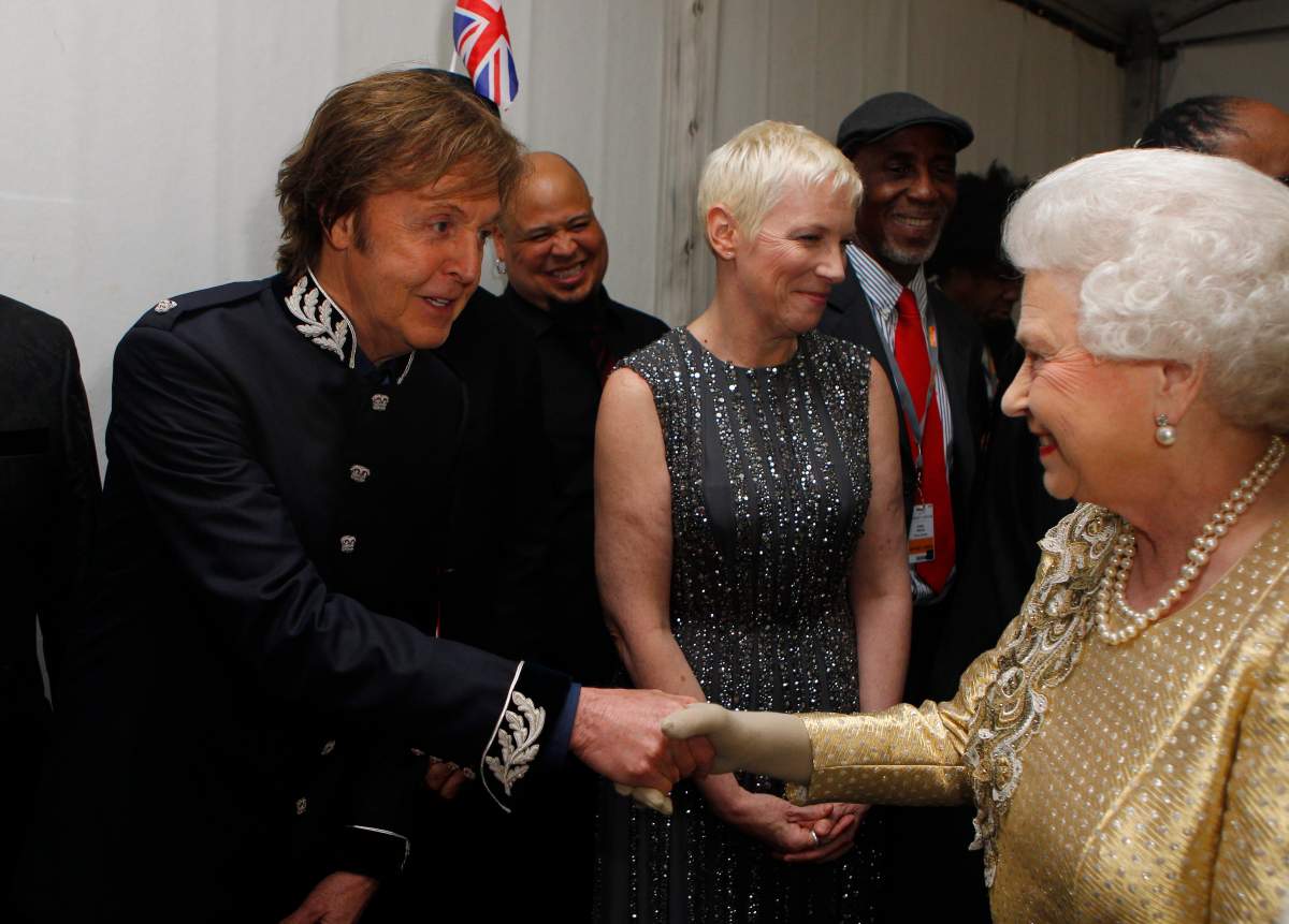 Paul McCartney shaking Queen Elizabeth II's hand.