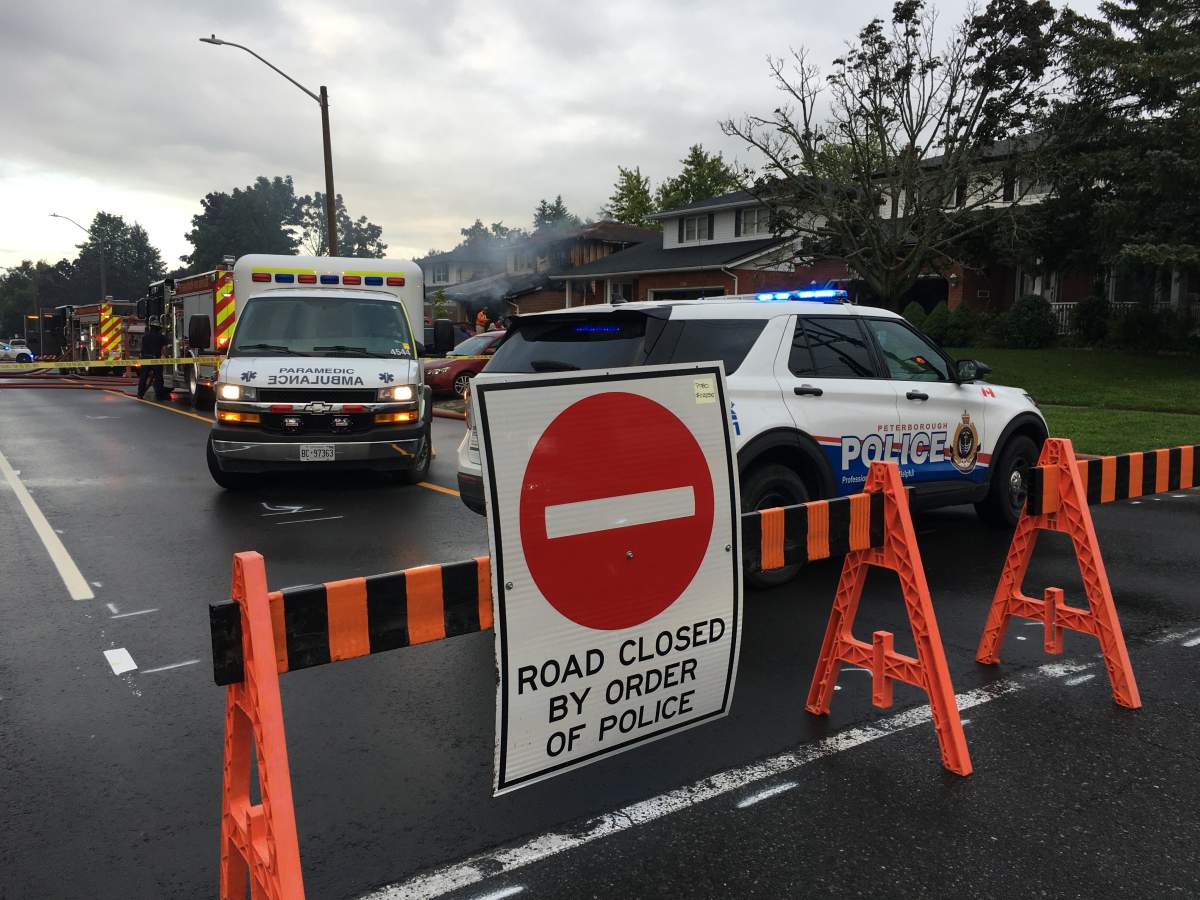 Peterborough police have closed a section of Woodglade following a house fire.