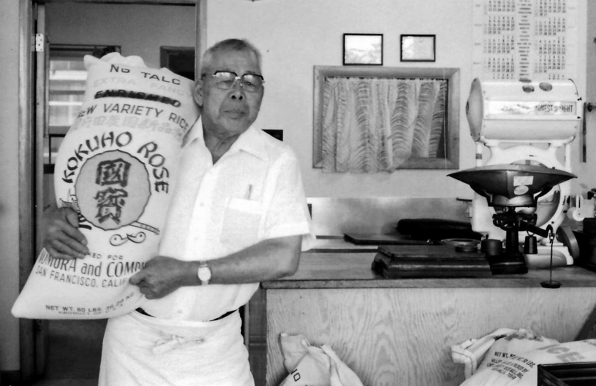 Ryutaro Nakagama holding a bag of the Kokuho Rose rice he imported to Canada.