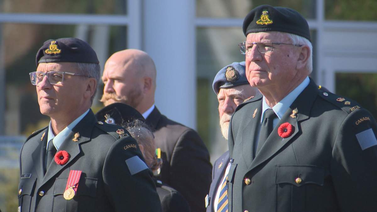 Two Legion members watch as a memorial service for Queen Elizabeth II takes place in Lethbridge on Sept. 19, 2022.