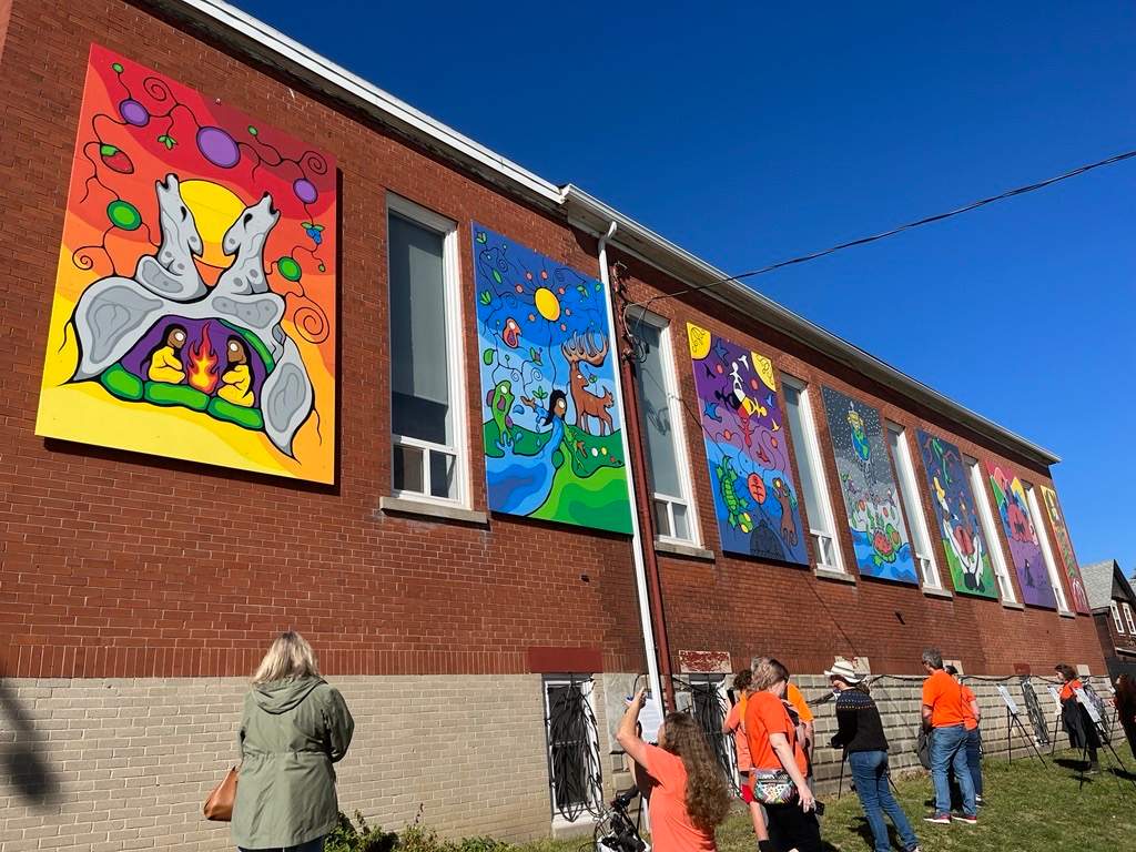The seven-panel "We Are Still Here" mural sits unveiled on the southern wall of the N'Amerind Friendship Centre.