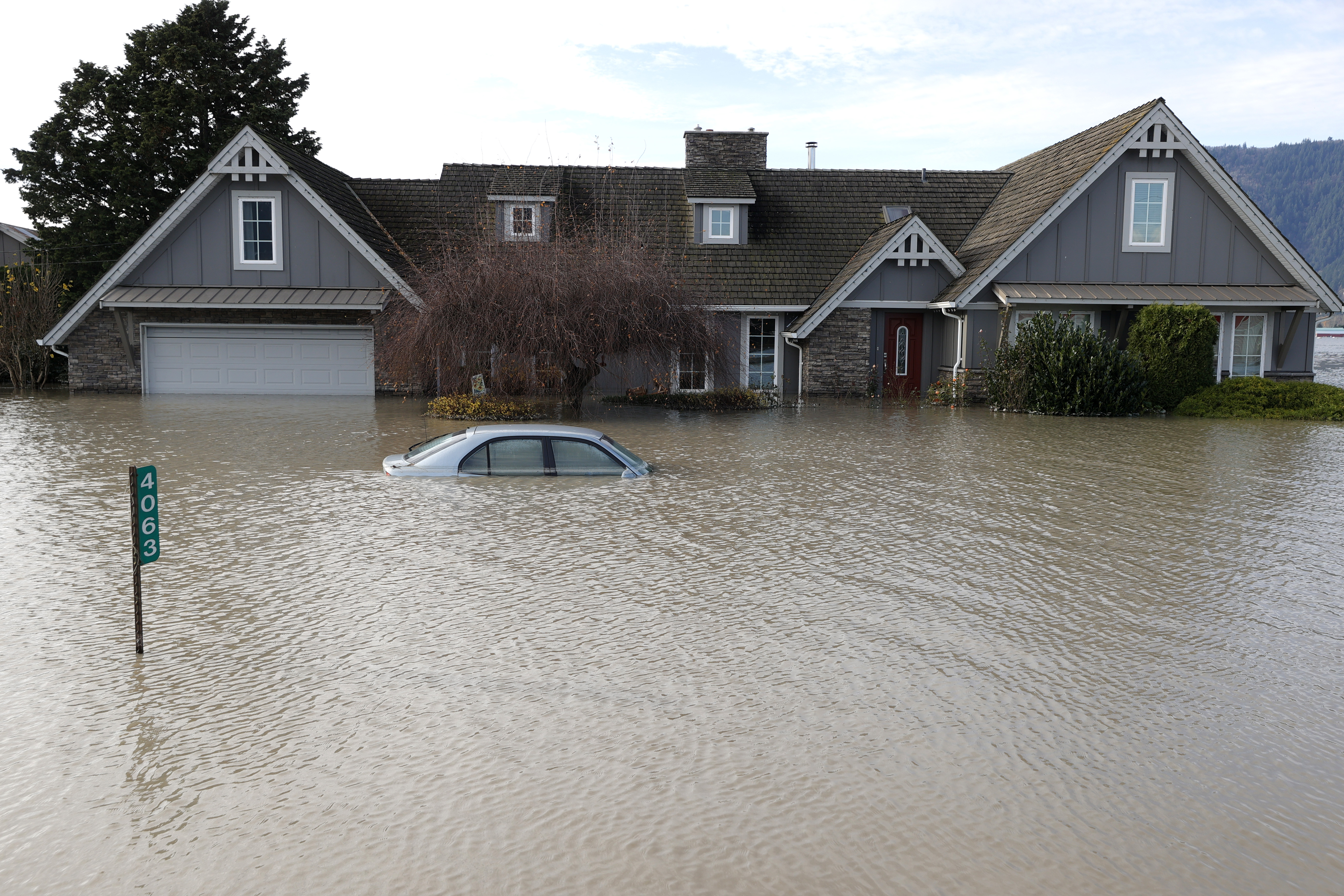 A home and car sit submerged in floodwaters on November 21, 2021 in Abbotsford, British Columbia.