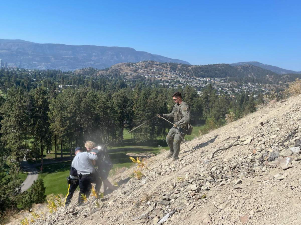 A woman was around three-quarters of the way down the steep mountainside, under a tree, when officers found her.