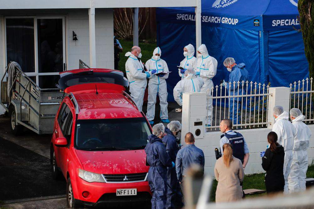 New Zealand police investigators work at a scene in Auckland on Aug. 11, 2022, after bodies were discovered in suitcases. A woman was arrested in South Korea on Thursday, Sept. 15, 2022, on two murder charges from New Zealand, where the bodies of two long-dead children were found last month in abandoned suitcases, authorities said.