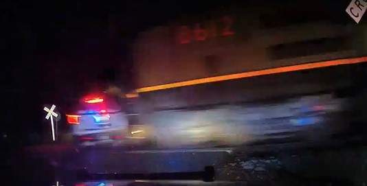 Newly released video shows the moment a train smashes into a police car that was parked on railroad tracks in Colorado with a handcuffed woman in the backseat.