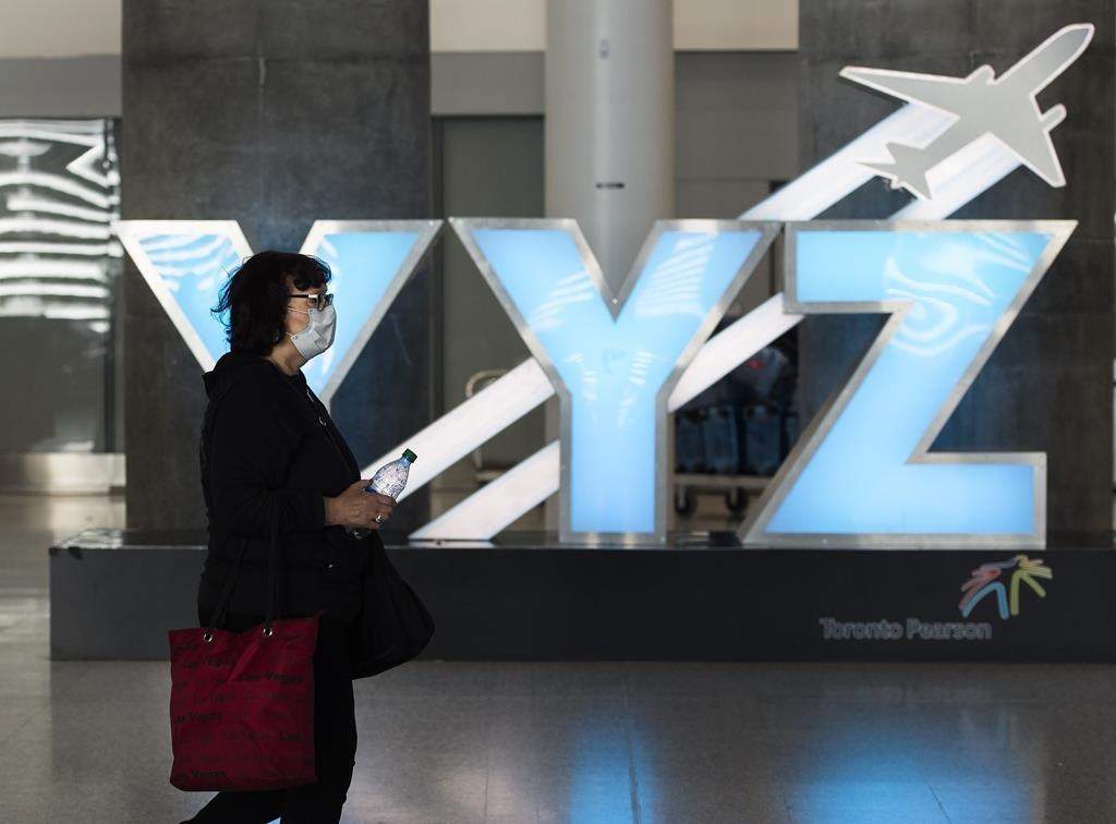 A woman walks through Pearson International Airport in Toronto on March 16, 2020.
