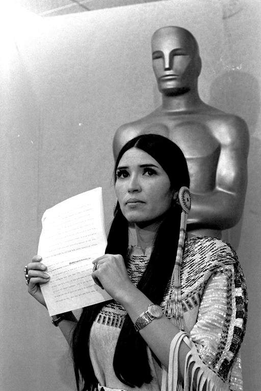 FILE - Sacheen Littlefeather, a Native American activist, tells the audience at the Academy Awards ceremony in Los Angeles, March 27, 1973, that Marlon Brando was declining to accept his Oscar as best actor for his role in "The Godfather." Sacheen Littlefeather died Sunday, Oct. 2, 2022, at her home in Marin County, Calif. She was 75.