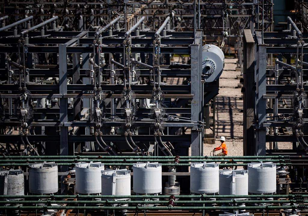 A worker rides a bike at a BC Hydro substation in Vancouver, on Friday, April 16, 2021. A new report from the utility says its power generating system is meeting challenges caused by severe drought in several British Columbia regions, even as levels in some southwestern reservoirs are at or near record-breaking lows. THE CANADIAN PRESS/Darryl Dyck.