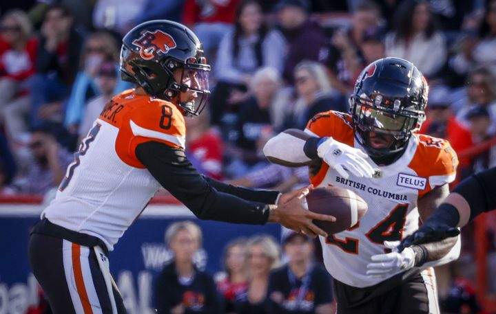 BC Lions quarterback Vernon Adams, left, hands the ball off to running back James Butler during first half CFL football action against the Calgary Stampeders in Calgary, Saturday, Sept. 17, 2022.