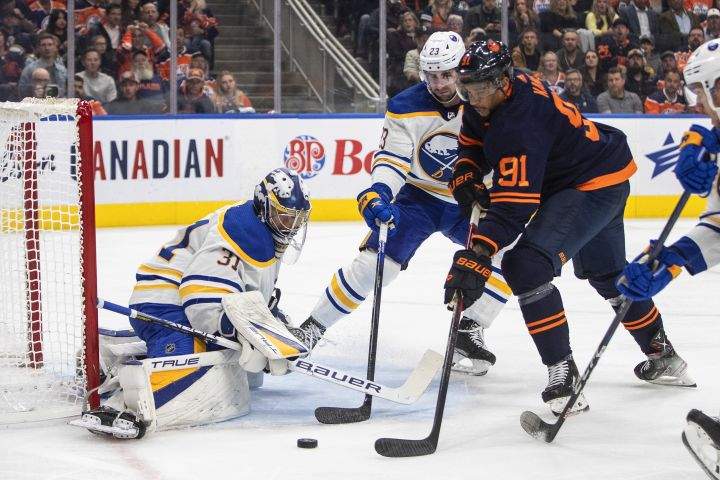 Buffalo Sabres goalie Eric Comrie (31) makes the save on Edmonton Oilers’ Evander Kane (91) as Mattias Samuelsson (23) defends during second period NHL action in Edmonton on Tuesday, October 18, 2022.