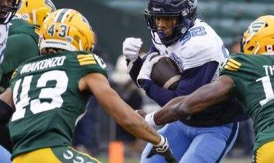 Toronto Argonauts' Javon Leake, centre, runs the ball as Edmonton Elks, left to right, Enock Makonzo, Matthew Thomas, and Treston Decoud close in during first half CFL football action in Edmonton, Saturday, Oct. 15, 2022.