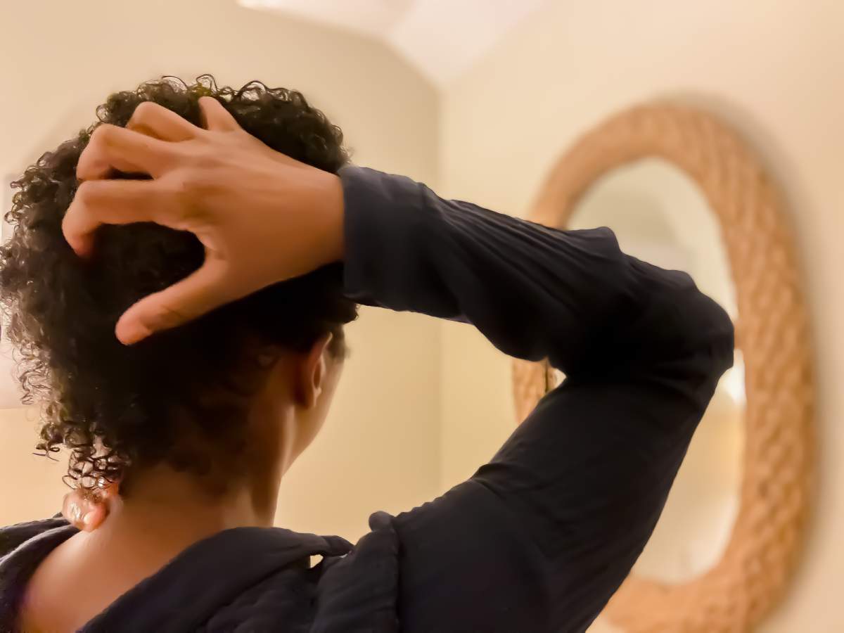A Black woman feels her hair in this photo illustration.