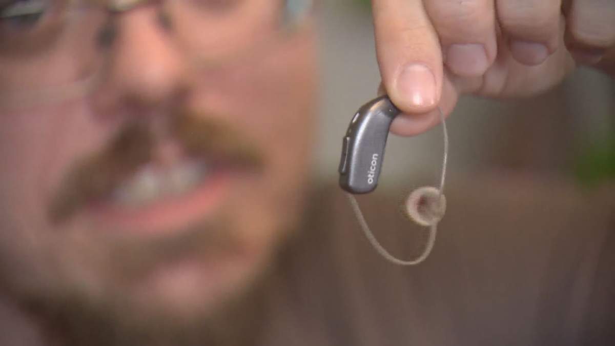 Jonathan Aschenbrener shows off his hearing aid.