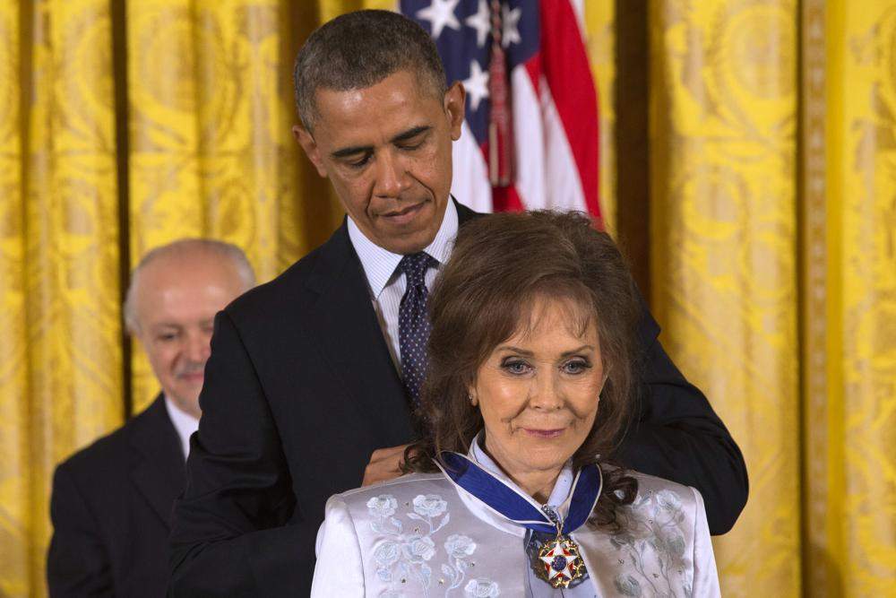 FILE - President Barack Obama awards country music legend Loretta Lynn with the Presidential Medal of Freedom, Wednesday, Nov. 20, 2013, during a ceremony in the East Room of the White House in Washington. Lynn, the Kentucky coal miner’s daughter who became a pillar of country music, died Tuesday at her home in Hurricane Mills, Tenn. She was 90.