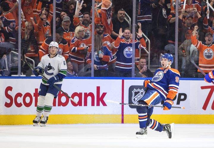 Vancouver Canucks’ Brock Boeser (6) looks on as Edmonton Oilers’ Connor McDavid (97) celebrates a goal during third period NHL action in Edmonton on Wednesday, October 12, 2022.