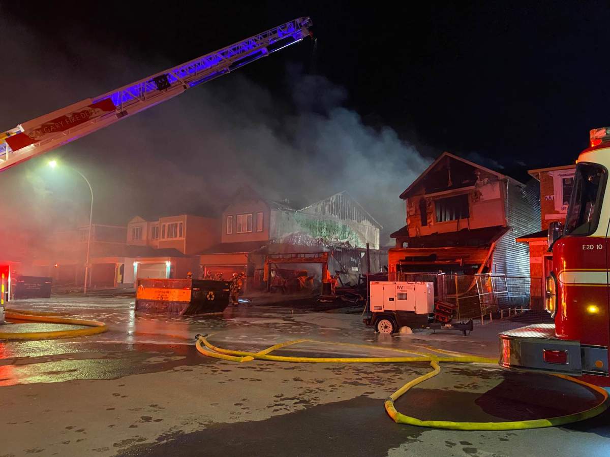 Calgary firefighters work to put out a multi-home fire in the new northeast neighbourhood of Cornerstone on Oct. 17, 2022.