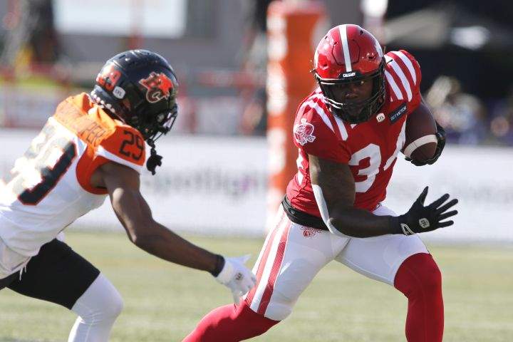 Calgary Stampeders running back Dedrick Mills, right, gets away from BC Lions defensive back Jalon Edwards-Cooper during first half CFL football action in Calgary, Saturday Aug. 13, 2022.