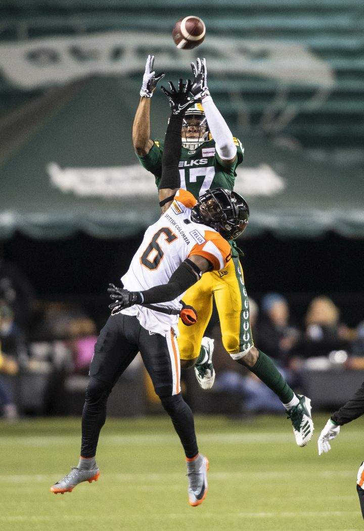 B.C. Lions’ T.J. Lee (6) and Edmonton Elks’ Dillon Mitchell (17) vie for the ball in the air during first half CFL action in Edmonton, Alta., on Friday October 21, 2022.