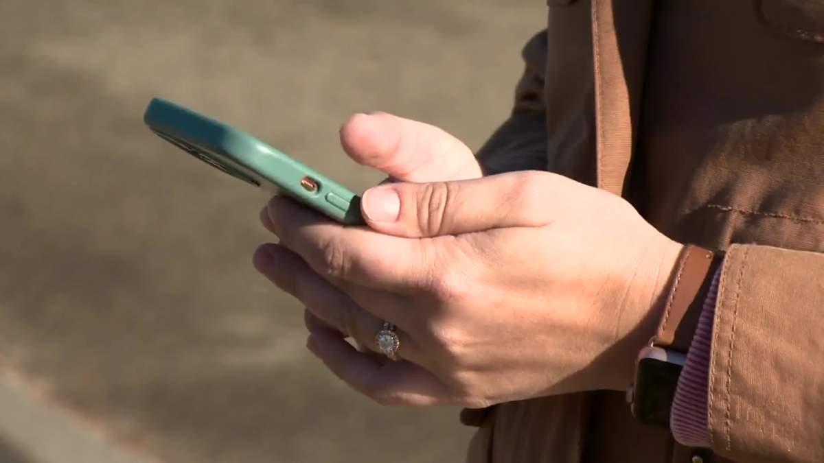 A woman in Edmonton, Alta. holding a cell phone on Thursday, Oct. 20, 2022.