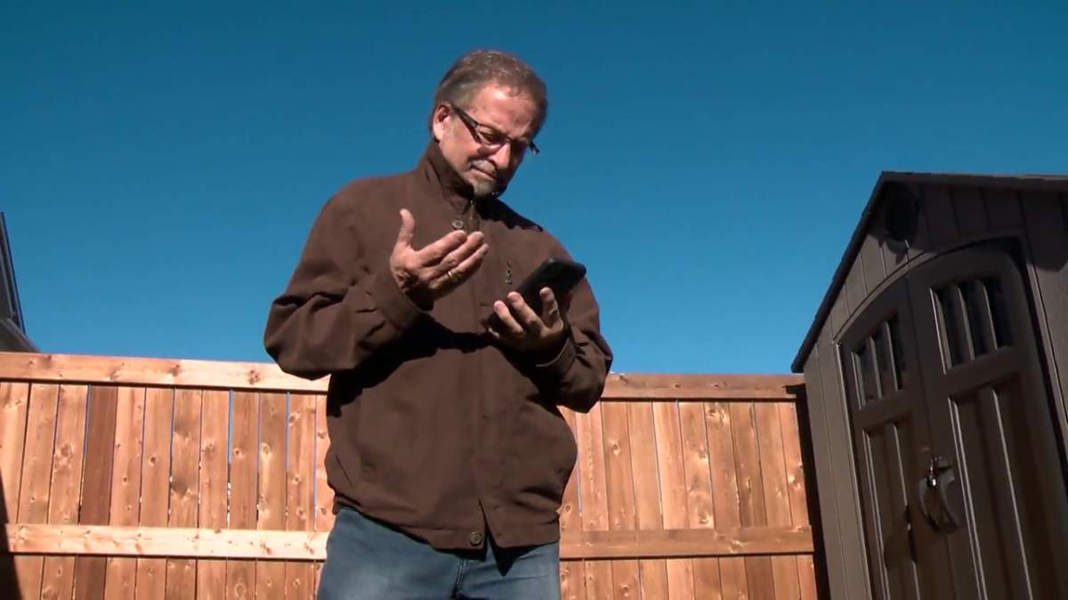 Edmonton resident Pierre Fagnan looking at his cellphone in the Summerside area on Thursday, Oct. 20, 2022.