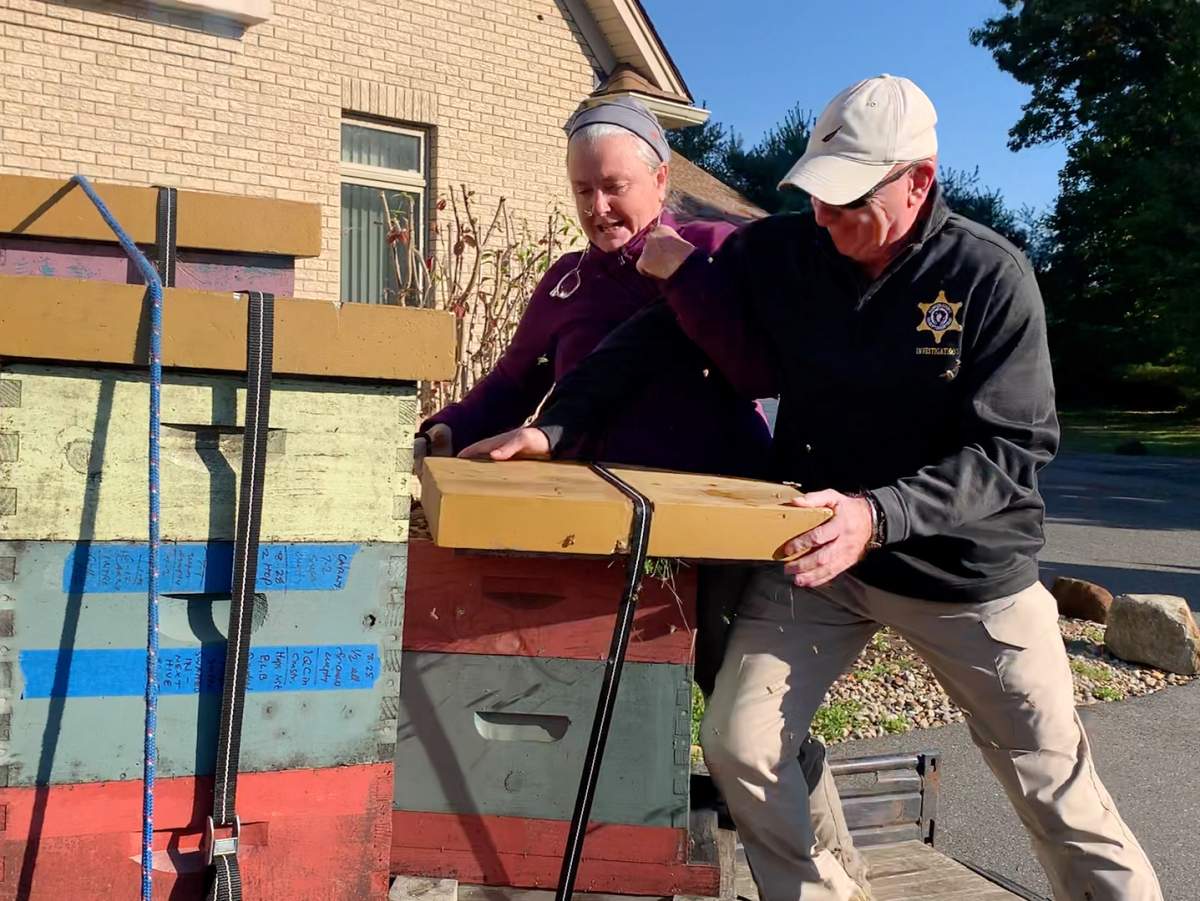 Rorie Susan Woods struggling with a deputy over a bee hive.