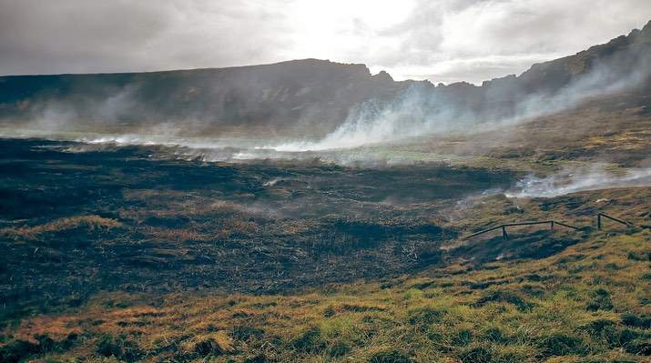 Easter Island with smoke coming from the scorched ground.