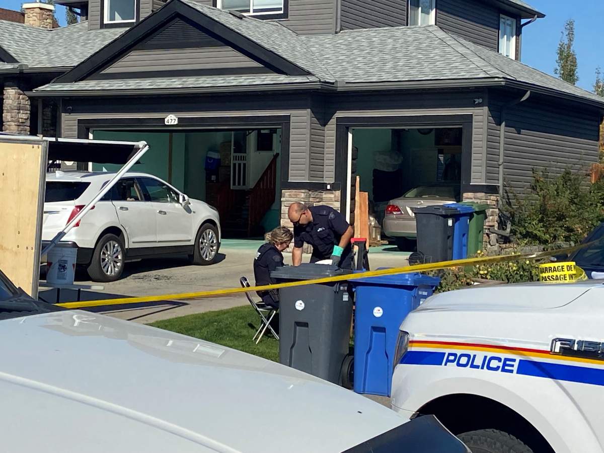 RCMP sift through glass and debris at the scene of the shooting, Oct. 8, 2022.