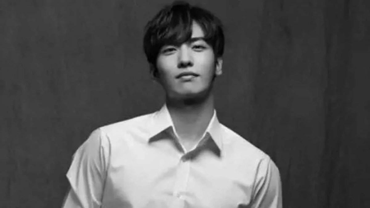 A black and white photo of Lee Jihan in a white button up shirt.