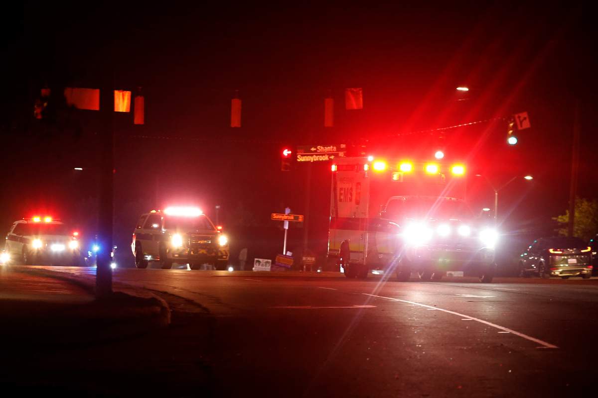 An ambulance believed to be carrying a shooting suspect arrives at Wake Medical Center Emergeny Room in Raleigh, N.C., Thursday, Oct. 13, 2022 surrounded by police.