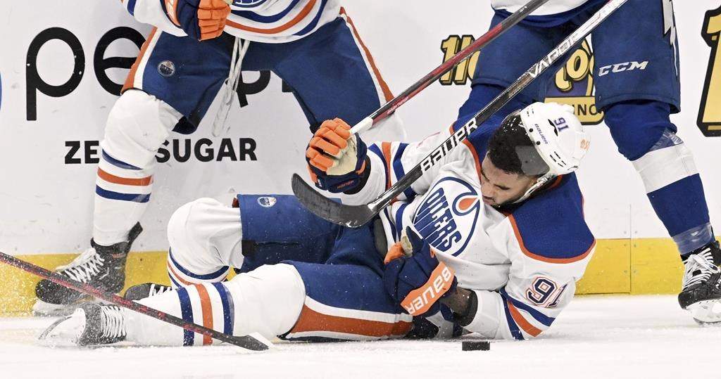 Edmonton Oilers forward Evander Kane (91) is knocked to the ice during the second period of an NHL hockey game against the Tampa Bay Lightning Tuesday, Nov. 8, 2022, in Tampa, Fla. Kane will miss three to four months after being cut on the left wrist by a skate blade during the play. THE CANADIAN PRESS/AP-Jason Behnken