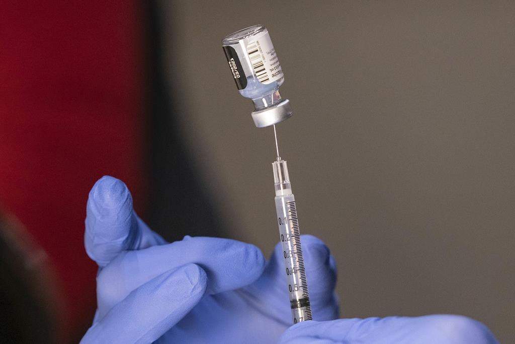 FILE - Pharmacist Ron Simono fills a syringe with a dose of the Pfizer-BioNtech COVID-19 vaccine during a vaccine clinic on Dec. 16, 2020, at Providence Alaska Medical Center in Anchorage, Alaska.