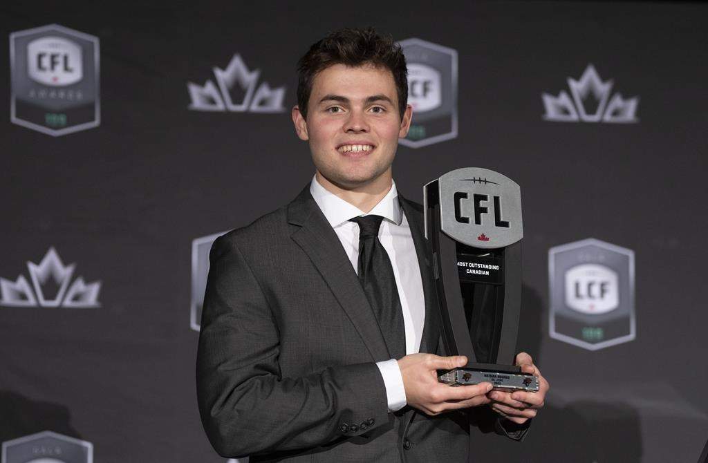 Most outstanding Canadian player, quarterback Nathan Rourke of the BC Lions, holds up his trophy during the CFL Awards in Regina, Thursday, Nov. 17, 2022. THE CANADIAN PRESS/Paul Chiasson