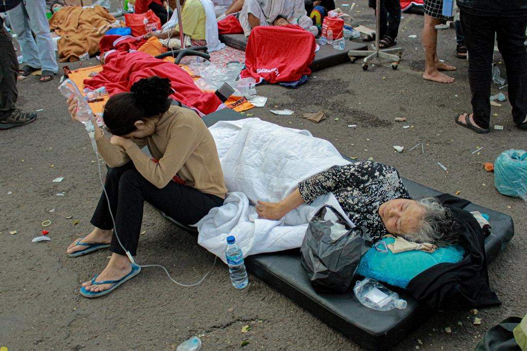 Earthquake survivors are treated outside of a hospital in Cianjur, West Java, Indonesia, Monday, Nov. 21, 2022. An earthquake shook Indonesia’s main island of Java on Monday damaging dozens of buildings and sending residents into the capital’s streets for safety. (AP Photo/Kholid)