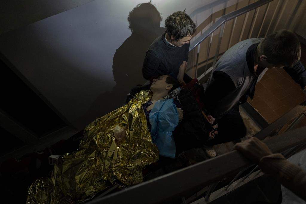 Staff carry 13-year-old Arthur Voblikova on a stretcher up the stairs to the operating room inside a hospital in Kherson, southern Ukraine, Tuesday, Nov. 22, 2022.