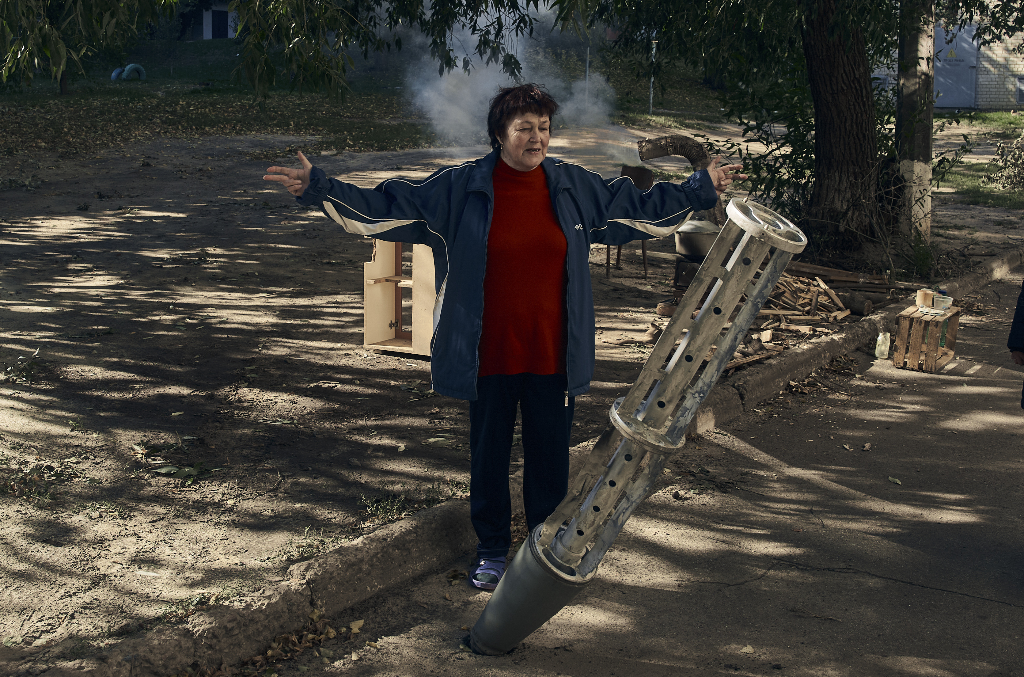 A resident stands near a rocket fragment near her house in Kupiansk, Ukraine, on Sept. 21. (AP Photo/Kostiantyn Liberov)