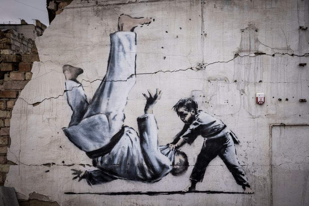Graffiti of a child throwing a man on the floor in judo clothing is seen on a wall amid damaged buildings in Borodyanka on November 11, 2022 in Kyiv Region, Ukraine.
