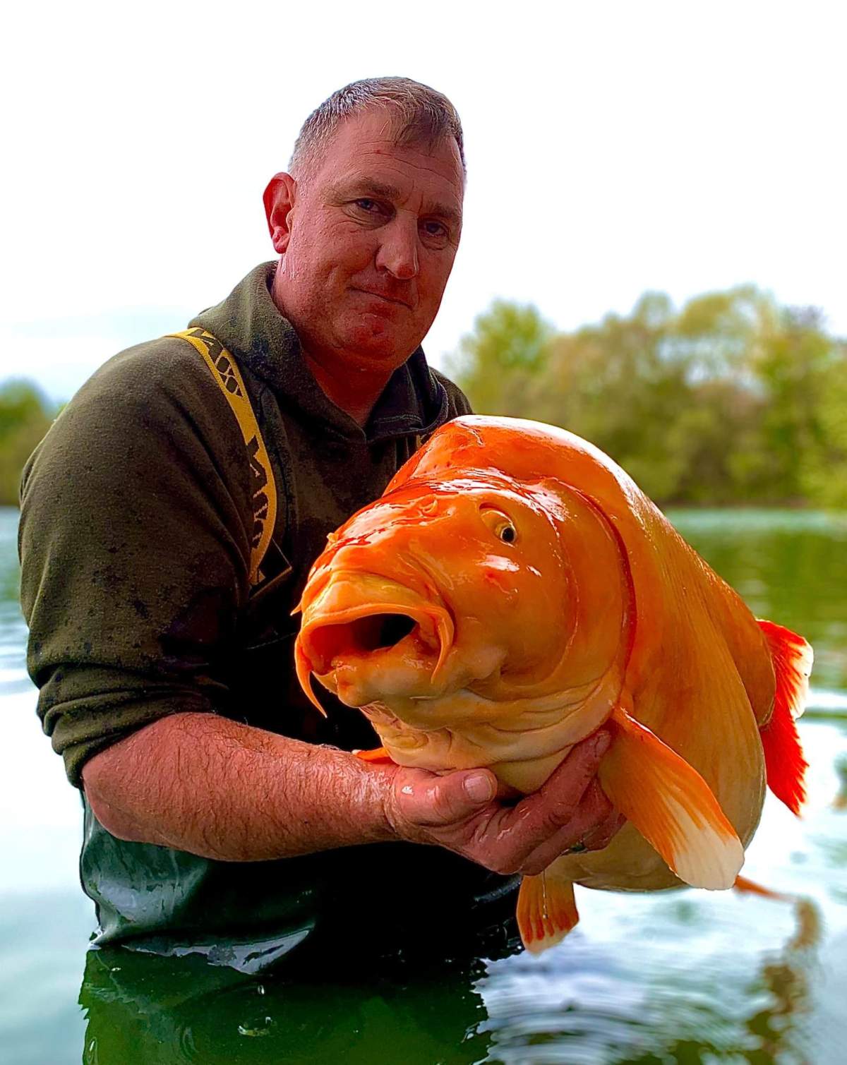 Angler Andy Hackett holds 'The Carrot,' a huge fish weighing almost 70 lbs., which he caught in Champagne, France