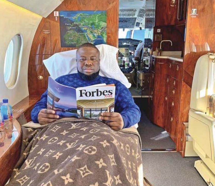 Ramon Abbas reading a copy of Forbes on a plane.