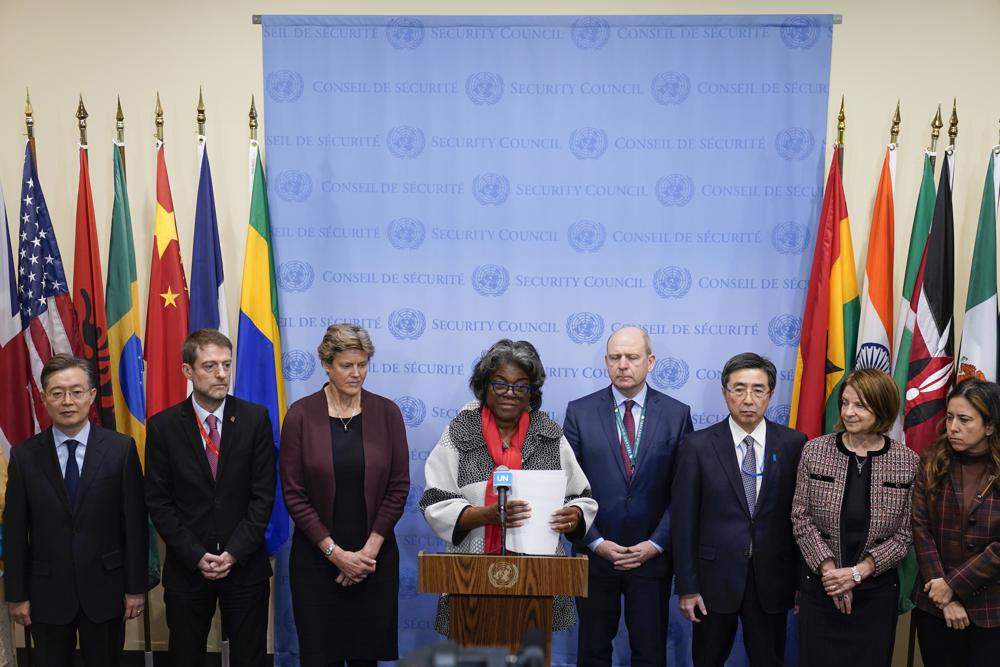 A row of ambassadors stand in front of a pddium.