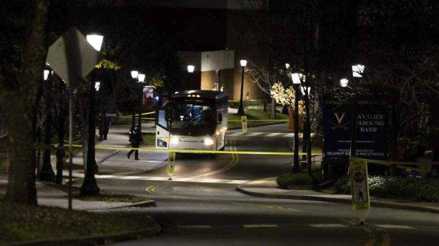 A bus idles behind police tape during an active shooter situation at the University of Virginia in Charlottesville, Va., on Monday, Nov. 14, 2022.