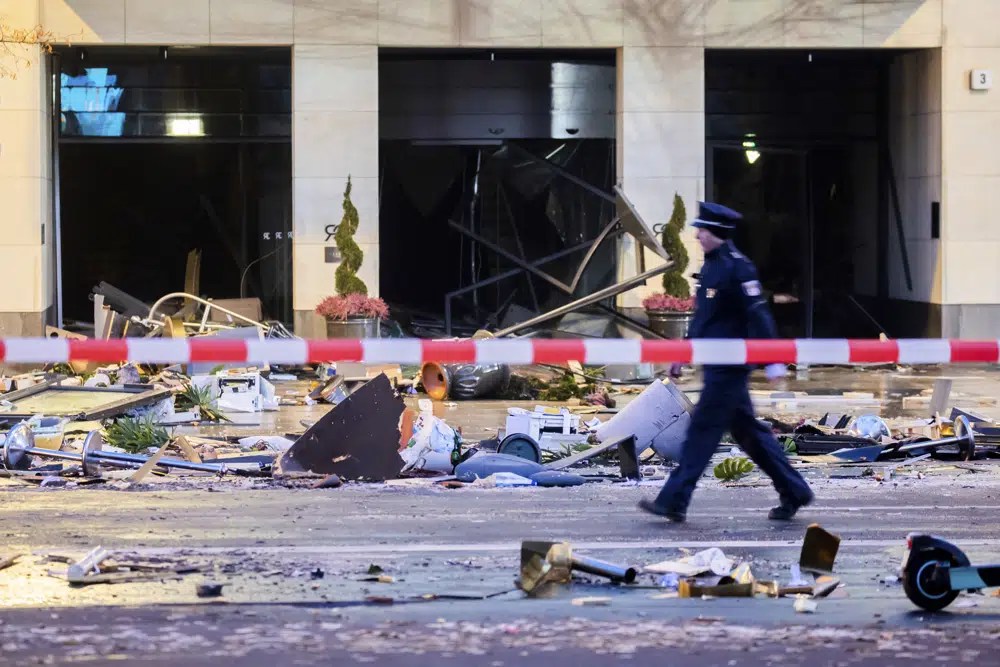 A police officer walks amid the debris on a closed road.