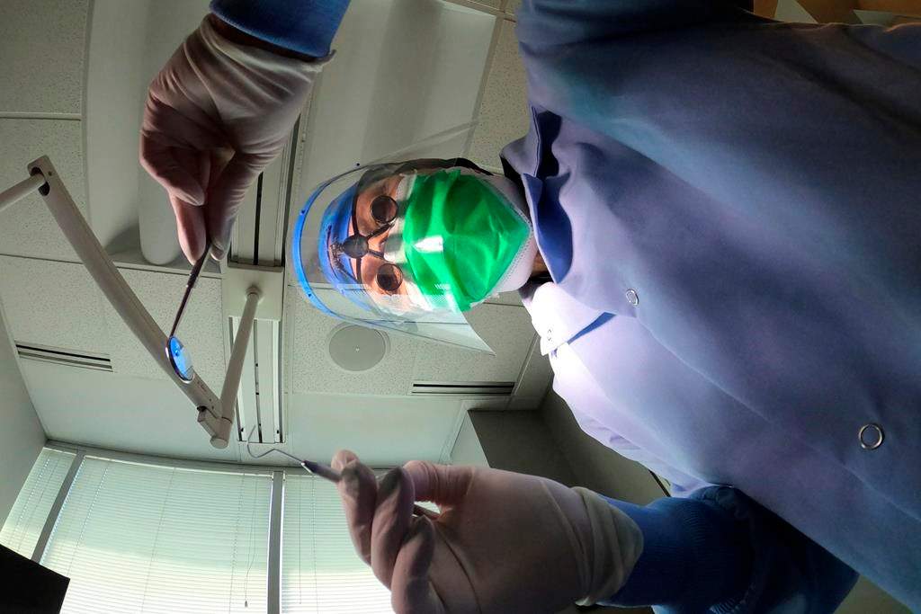 A dentist holds instruments in this 2022 file photo.