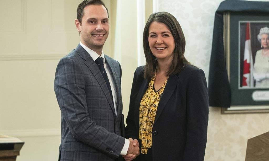 Matt Jones shakes hands with Alberta Premier Danielle Smith after he was sworn into cabinet as minister of affordability and utilities in Edmonton on Oct. 24, 2022. The Alberta government has introduced legislation to implement inflation-fighting rebates and payouts announced recently by Premier Danielle Smith. THE CANADIAN PRESS/Jason Franson.