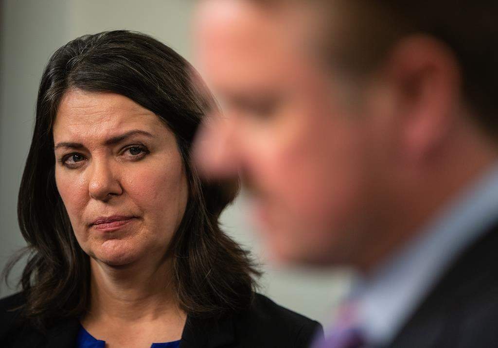 Alberta Premier Danielle Smith watches Minister of Justice and Solicitor General of Alberta Tyler Shandro speak at a press conference after the Speech from the Throne in Edmonton, Tuesday, Nov. 29, 2022. 