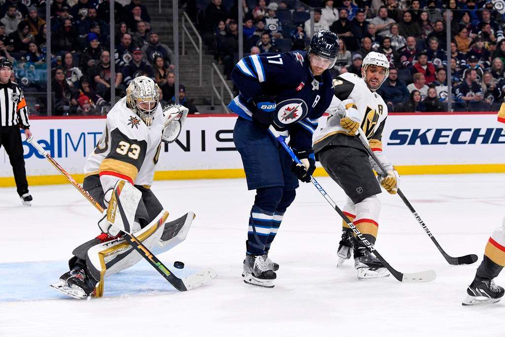 Vegas Golden Knights goaltender Adin Hill (33) makes a save as Winnipeg Jets’ Adam Lowry (17) and Alec Martinez (23) look for the rebound during second period NHL action in Winnipeg on Tuesday December 13, 2022.