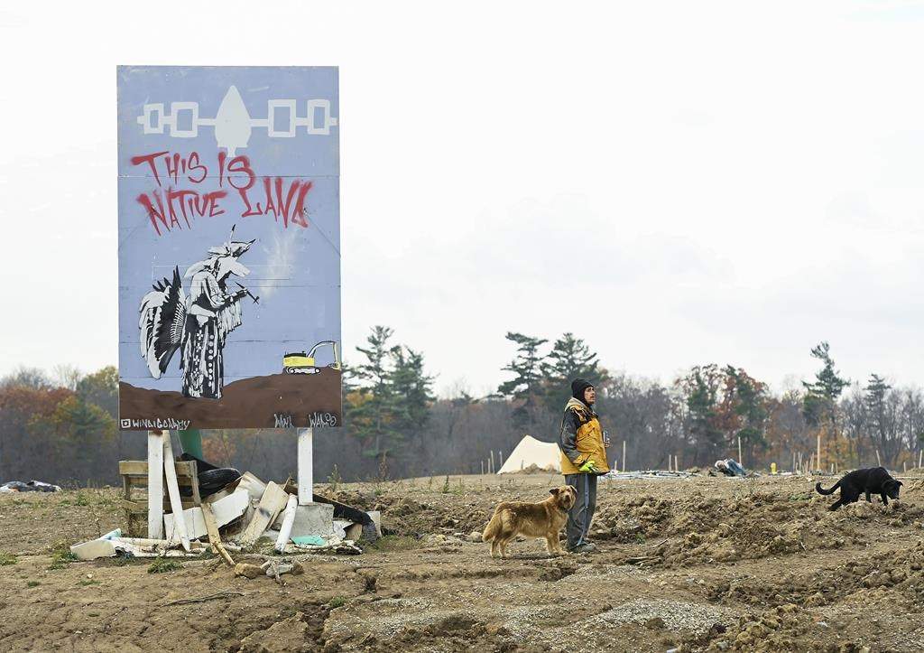 An Indigenous Mohawk called by the name Wack camps out at a construction site at the centre of an Indigenous land dispute in Caledonia, Ont., Thursday, Oct. 29, 2020. An Ontario judge has granted a permanent injunction to a home developer barring Indigenous demonstrators who have been occupying the property for more than two years. THE CANADIAN PRESS/Nathan Denette.