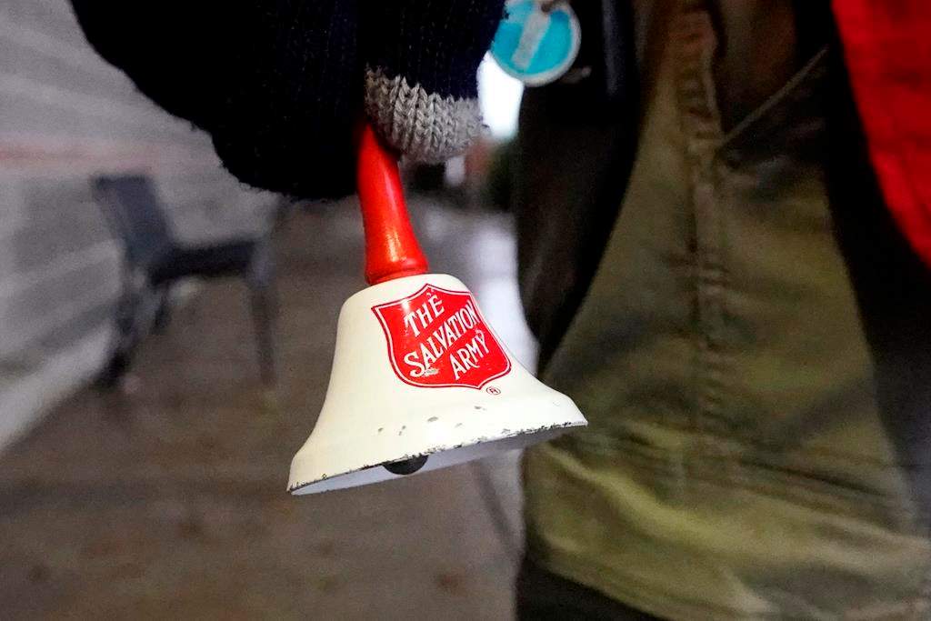 A Salvation Army bell is rung by the charity's red donation kettle in front of a grocery store, in Lynden, Wash., Tuesday, Dec. 8, 2020