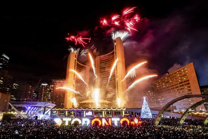 Revellers watch the New Year's fireworks after midnight at Nathan Philips Square in Toronto, Wednesday, Jan. 1, 2020. 