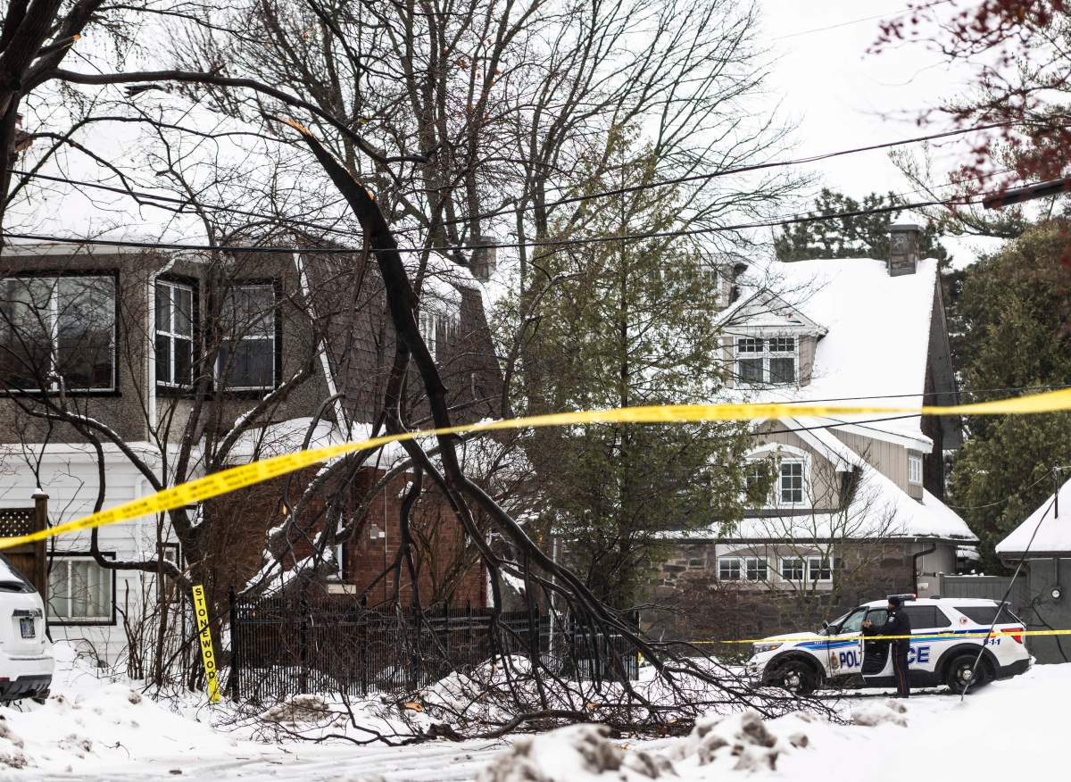 Police block off a section of road after a tree branch broke off near a home in Ottawa during a major storm on Friday, Dec. 23, 2022.